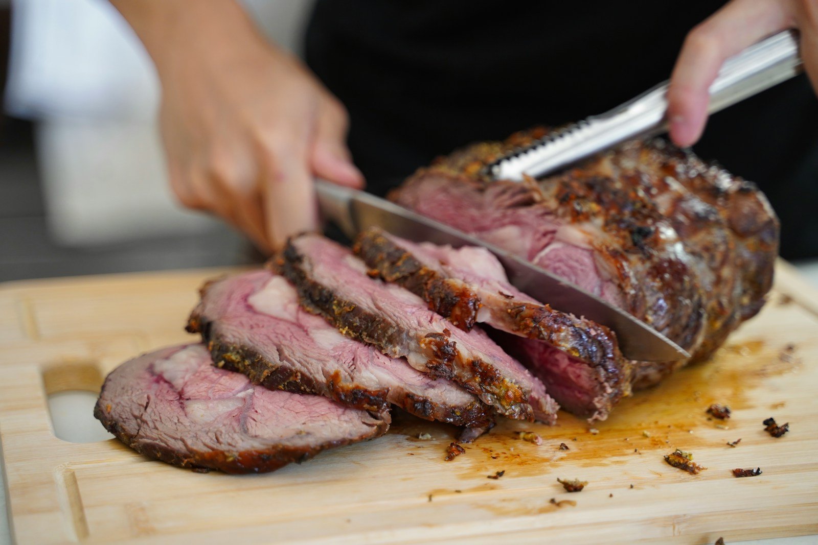 Carving a roasted brisket on a wooden cutting board
